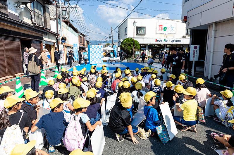 佐賀銀行神埼支店前の交差点に集まる児童たち